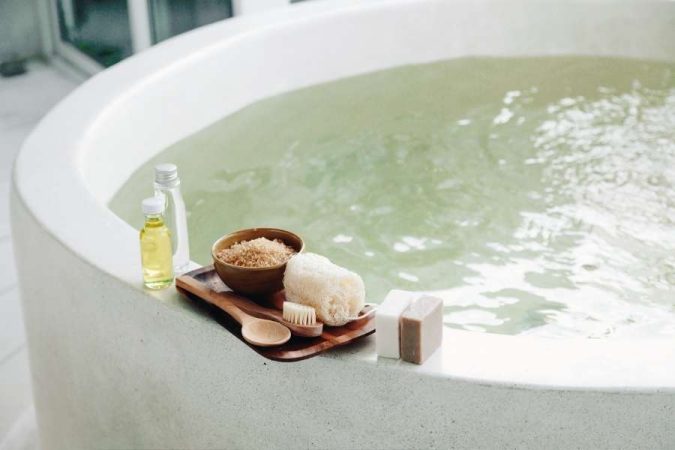 Un bain moussant relaxant dans une salle de bain esprit spa avec des accessoires de soin naturels.